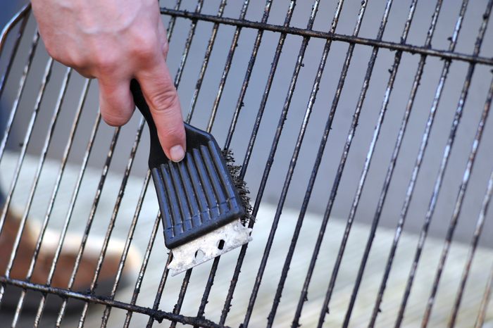 cleaning grill with wire brush close up