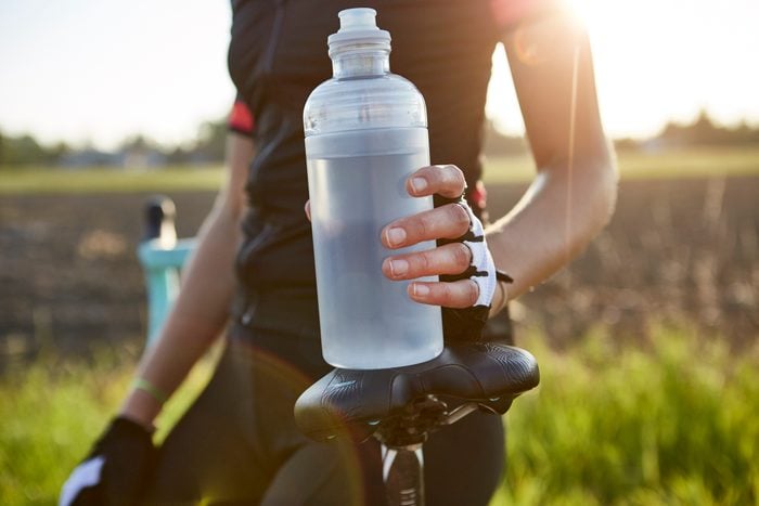 close up of cyclist holding water bottle