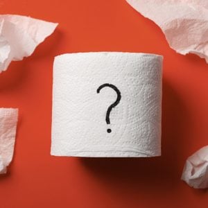 toilet paper roll with question mark on red background