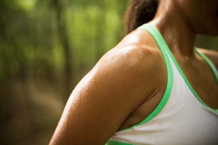close up of woman's sweaty shoulder outside during exercise