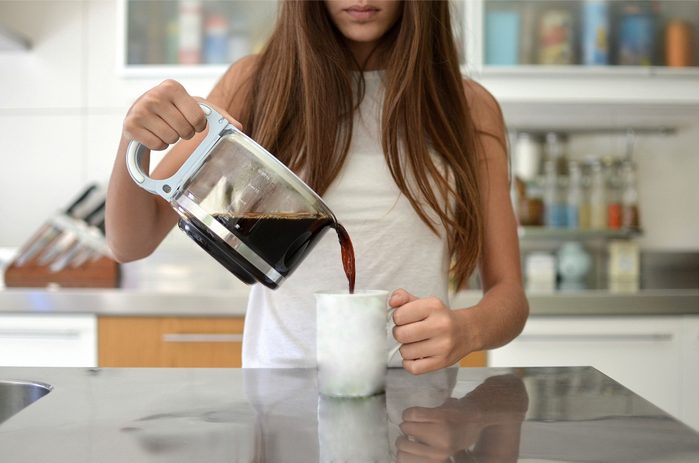 woman pouring coffee into mug
