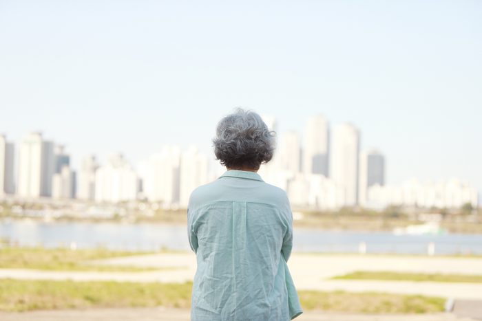 rear view of senior woman looking at view of city buildings