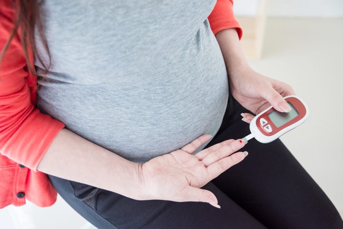 Midsection Of Pregnant Woman Checking Diabetes