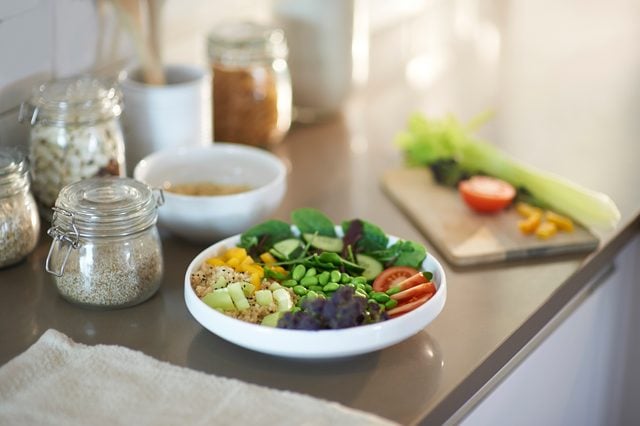 Healthy vegan salad bowl and plastic free items on kitchen worktop.