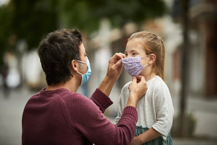Father Putting Home Made Face Mask on Little Daughter