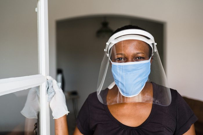 Covid-19: Portrait of a female worker wearing face shield and mask