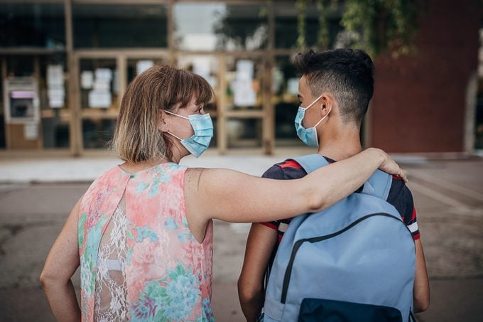 mother walking son to school wearing face masks