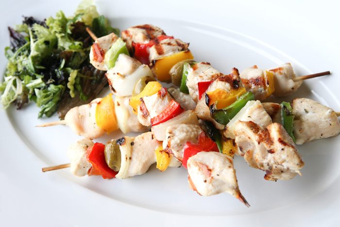 grilled chicken kabobs on plate with salad