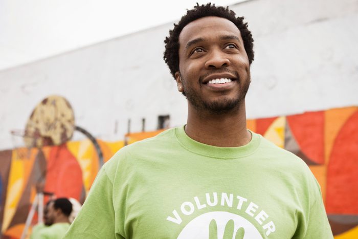 close up of smiling man wearing volunteer shirt