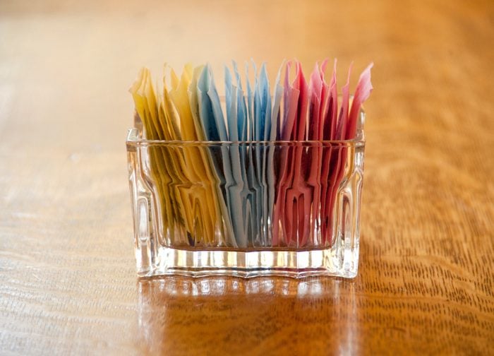 close up of artificial sweetener packs on table in restaurant