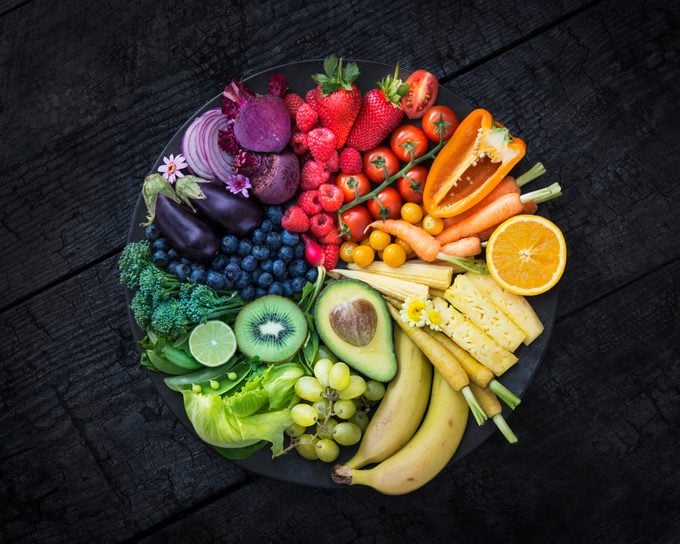 Multicoloured fruit and vegetables in a black bowl