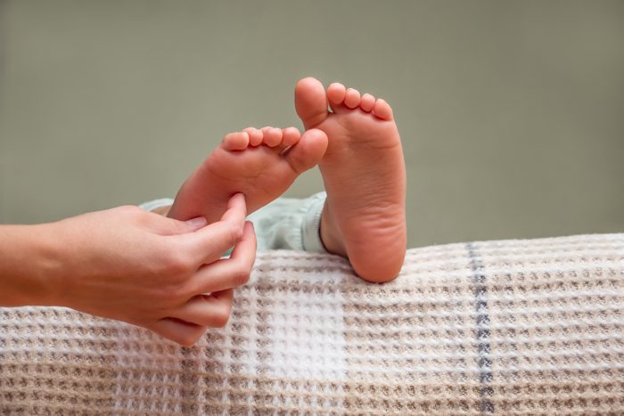 close up of hand tickling child's feet