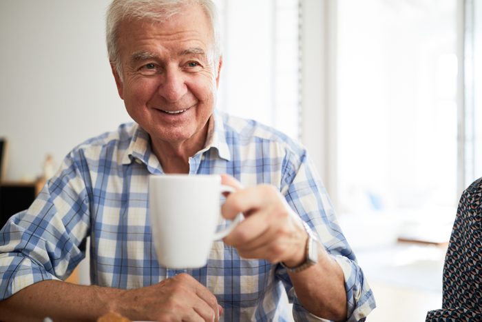 Senior man having tea at home
