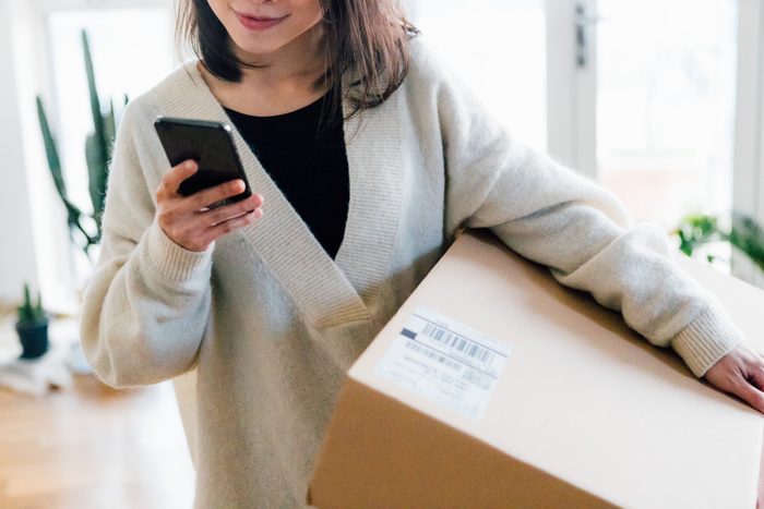 Smiling woman receiving parcel at home