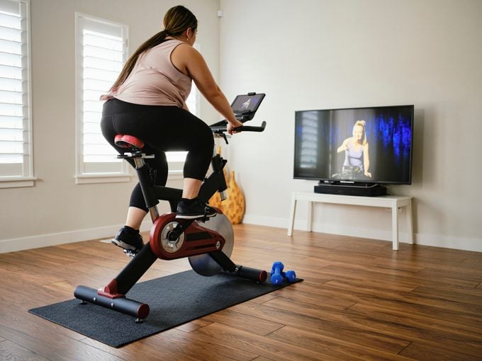 Woman Using Exercise Bike in a Home