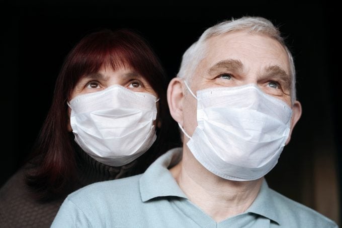 Portrait of senior couple wearing masks at home