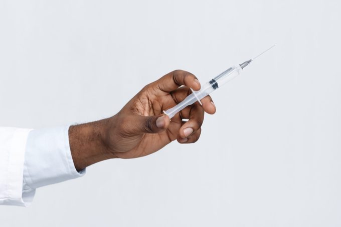 Cropped hand of doctor holding an injection