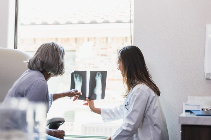 Senior woman talks with doctor about foot x-ray