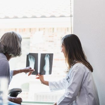 Senior woman talks with doctor about foot x-ray