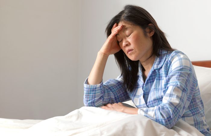 Woman with head ache in bed