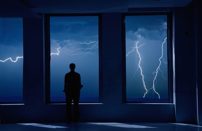 Man standing in window during storm.