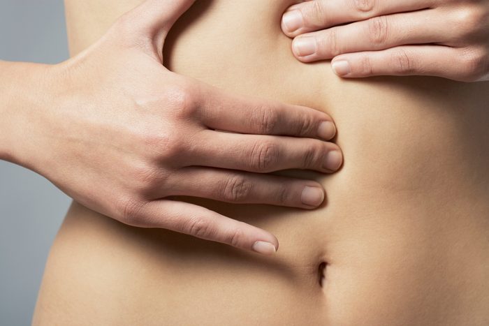 Woman with hands on stomach