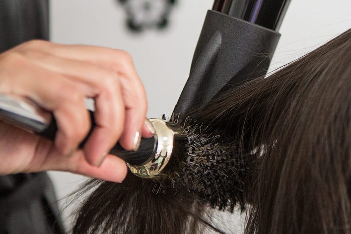 Close up of a hairdresser blow-drying woman's hair