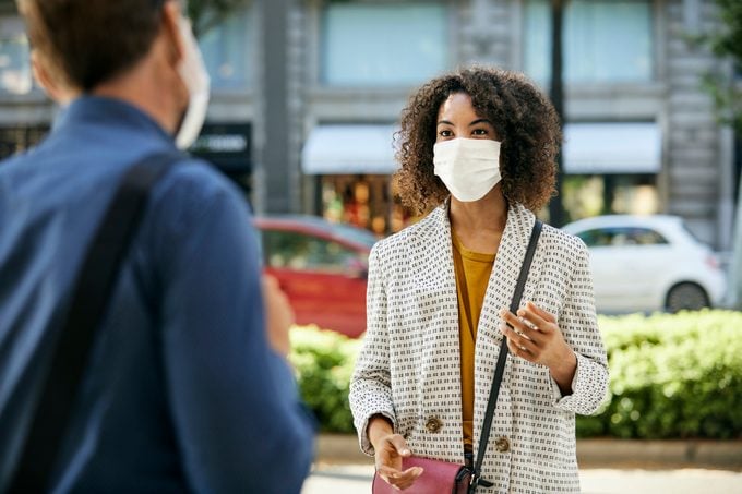 woman Wearing Face Mask Talking To man During COVID-19 Pandemic