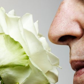 Senior man smelling rose, close-up