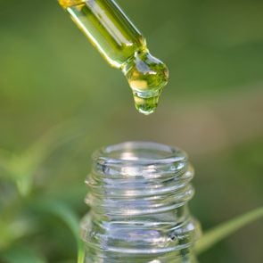 Droplet hemp oil into a glass bottle, CBD Hemp oil, Concept of herbal alternative medicine.Scientific research.