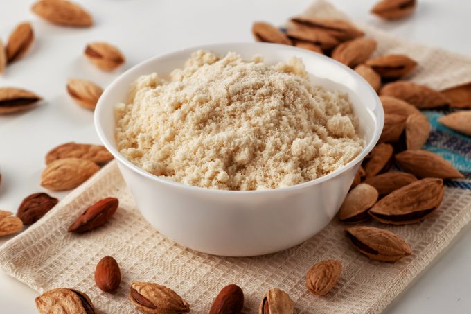 almond flour in white bowl with almonds on table