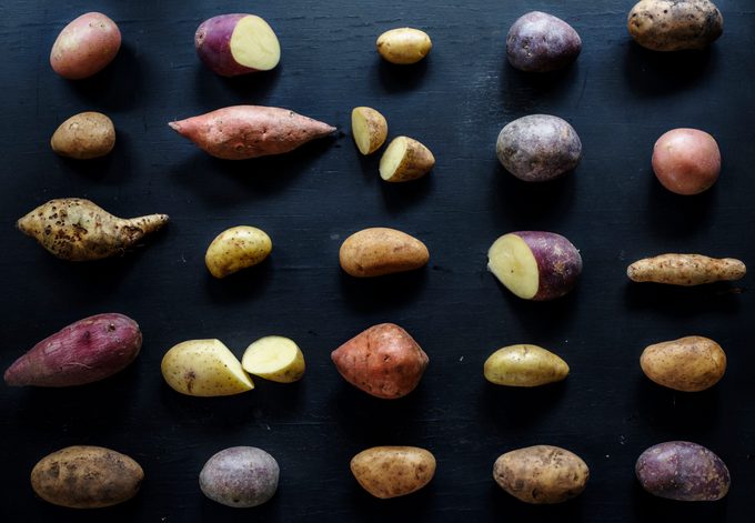 Closeup of fresh various organic potatoes on black background