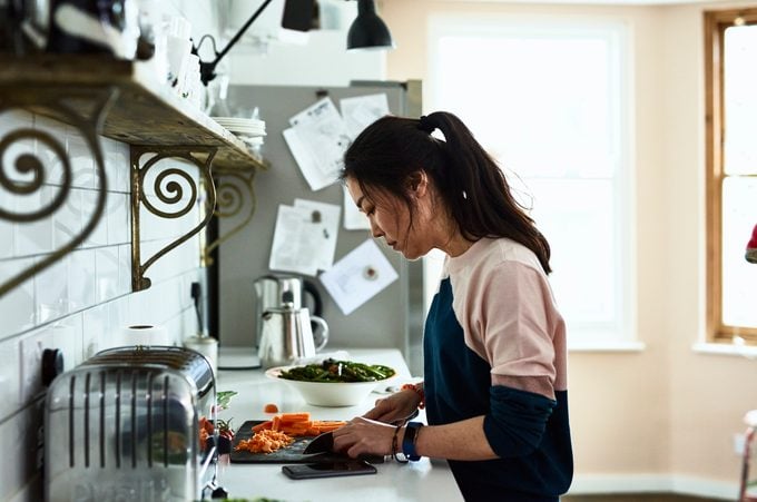 Mujer adulta media picar verduras en la cocina