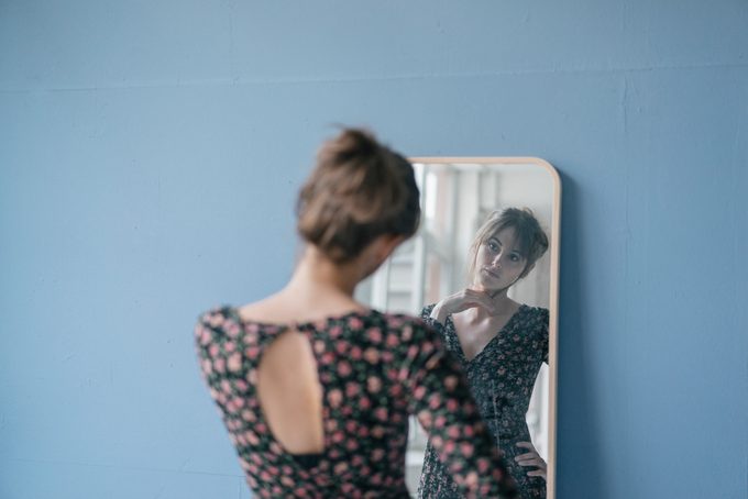 woman looking at herself in mirror