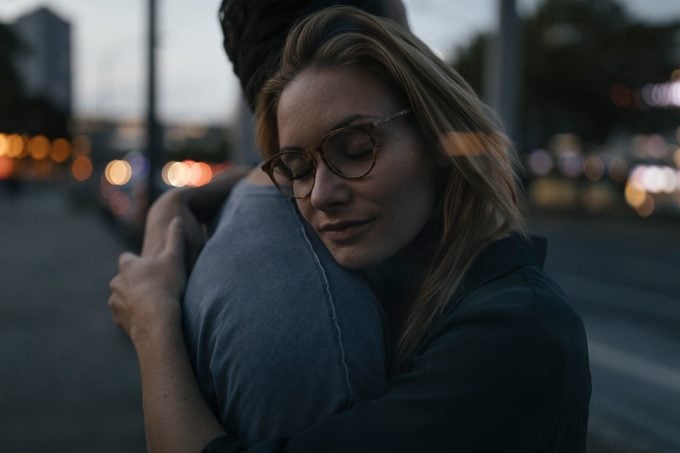 Young couple hugging in the city at dusk