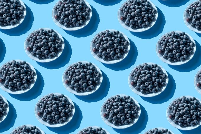 Blueberries on the plate on the blue background
