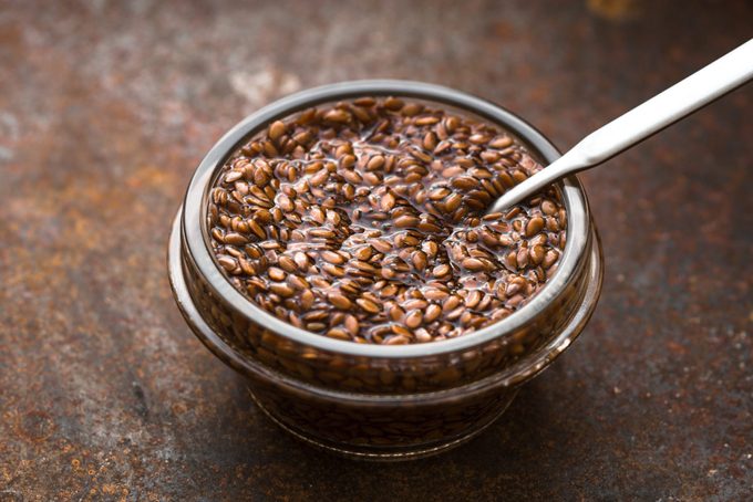 Bowl of flax seeds in water on horizontal metal background