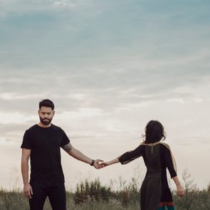 Couple in field holding hands