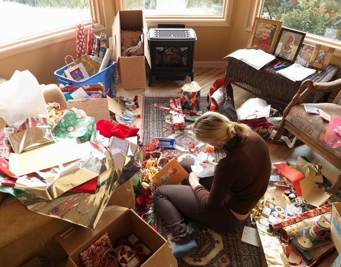 Woman sitting in living room writing on Christmas cards, elevated view
