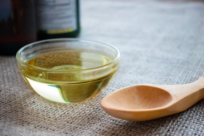 Liquid coconut MCT oil in round glass bowl with wooden spoon and bottles. Health Benefits of MCT Oil. Triglycerides, a form of saturated fatty acid.