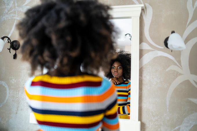 Vrouw kijkt naar haar spiegelbeeld in de spiegel