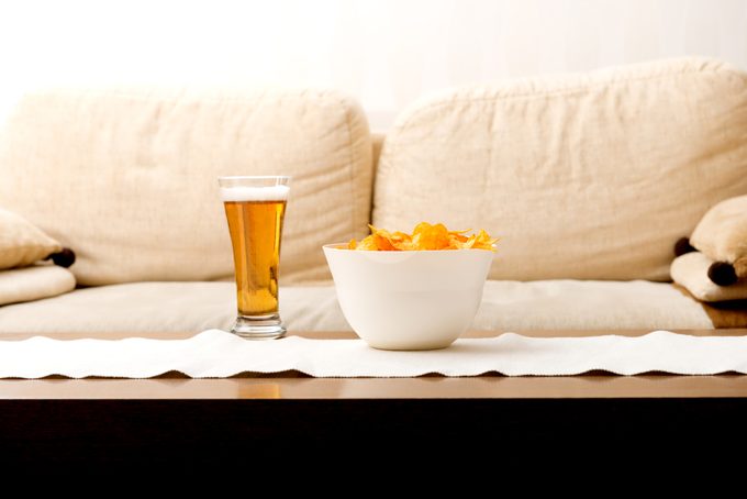 Close-up de cerveja e lanche na tigela na mesa em casa