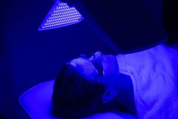 woman having blue LED light facial therapy treatment