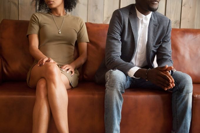 African-american couple sitting on couch after quarrel, bad relationships concept