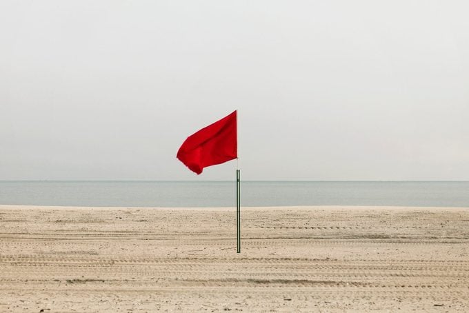 Red flag on empty beach, Coney Island, Brooklyn, New York