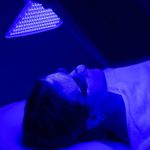 Young Woman Having Blue Led Light Facial Therapy Treatment In Beauty Salon. Beauty And Wellness