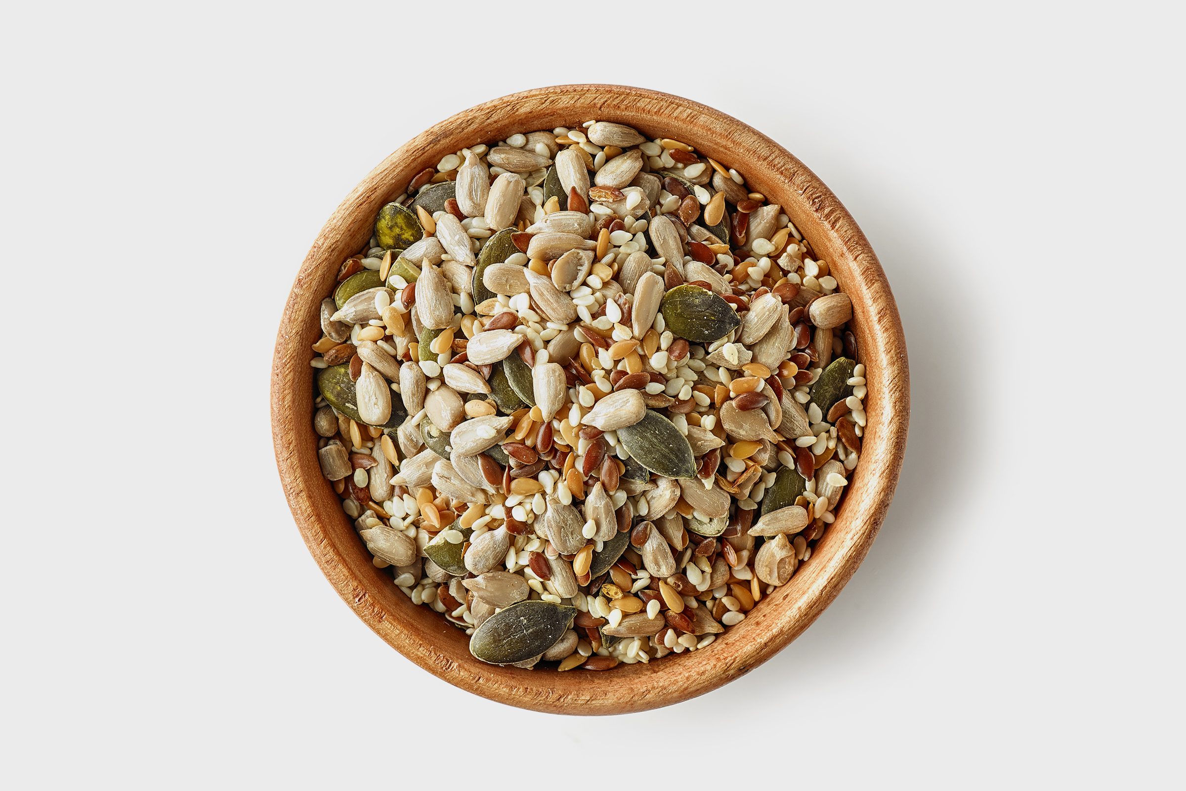 bowl of various seeds on white background