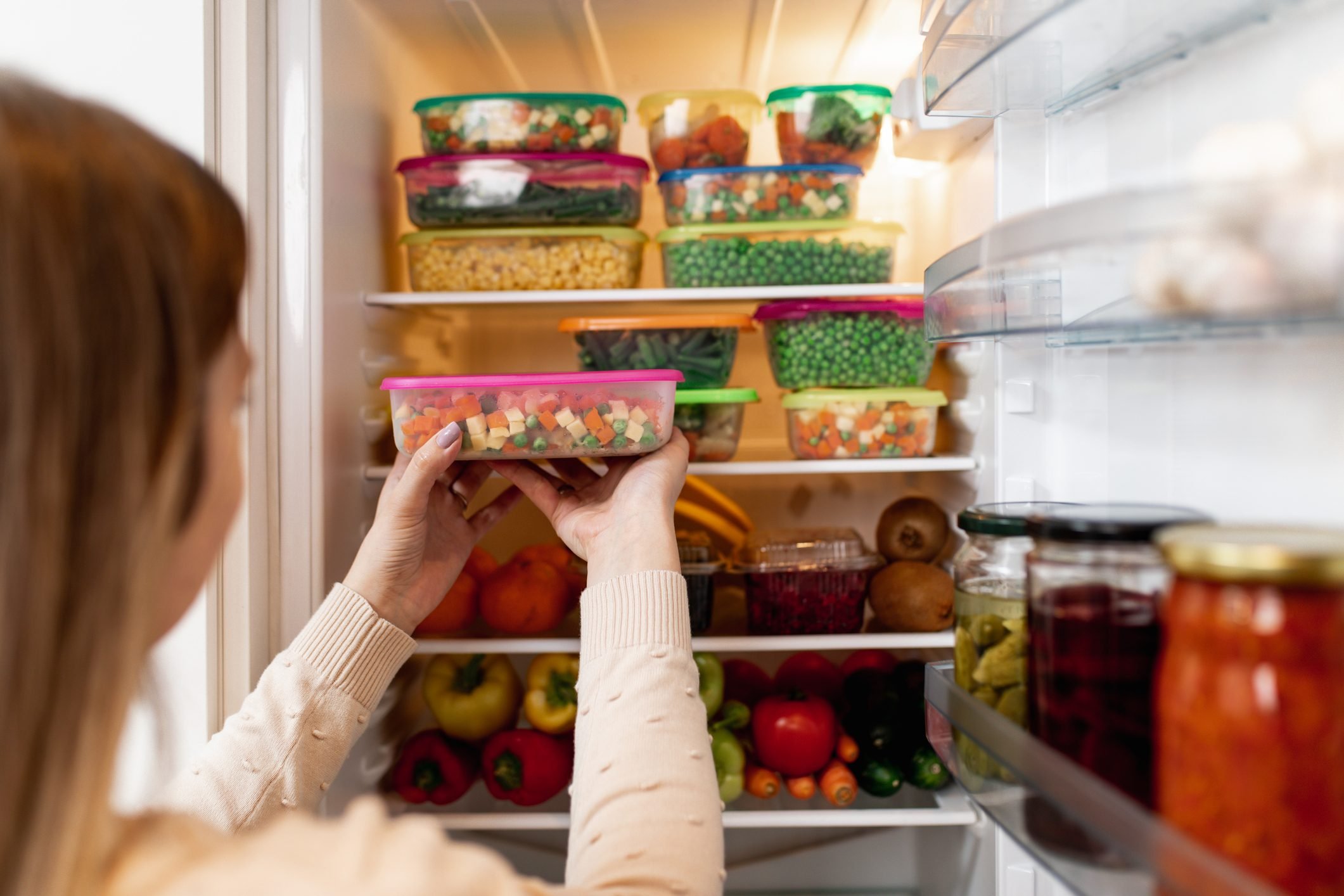 Vrouw die rauw voedsel uit de koelkast haalt