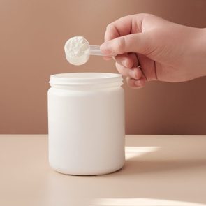 Cropped Hand Putting Coin In Jar On Table