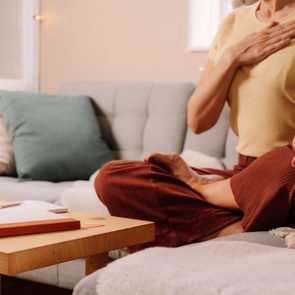 Woman indoors relaxing meditating and doing breathing exercises